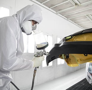 Collision Center Technician Painting a Vehicle | Markquart Toyota in Chippewa Falls WI